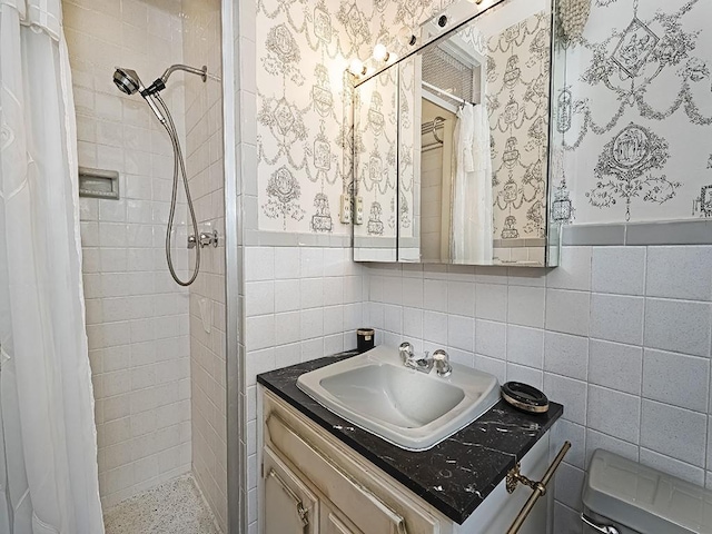 bathroom with a shower with curtain, vanity, toilet, and tile walls