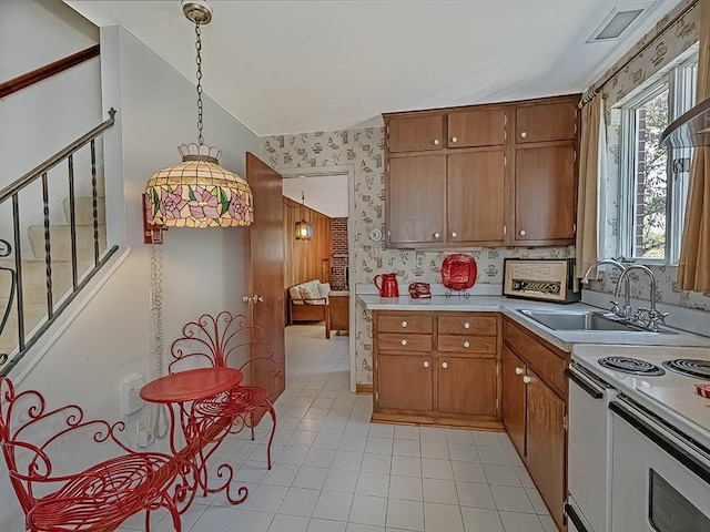 kitchen with sink, lofted ceiling, hanging light fixtures, and light tile patterned floors