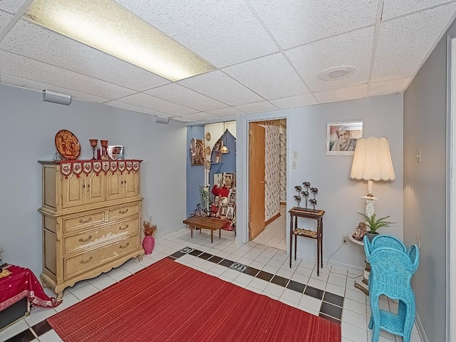 sitting room featuring light tile patterned floors and a drop ceiling