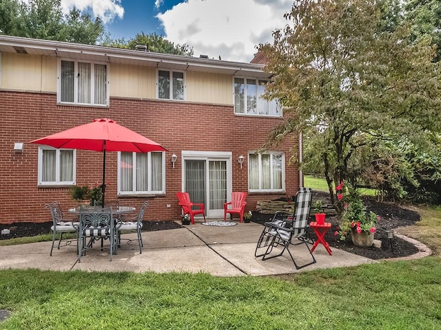 back of property with a yard and a patio area