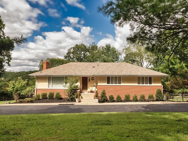 ranch-style home featuring a front yard