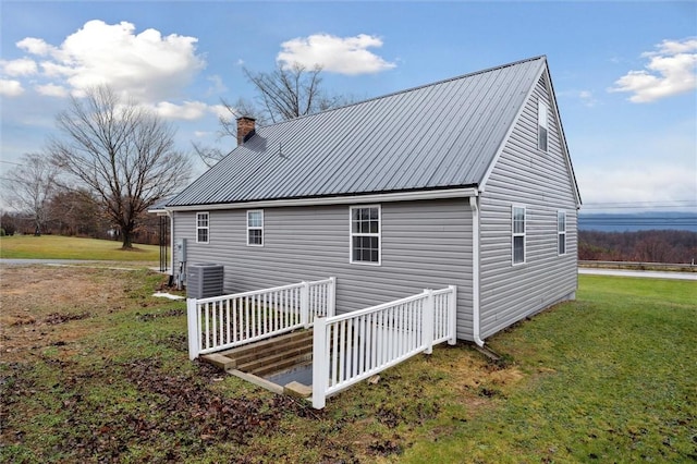 view of home's exterior featuring cooling unit and a yard