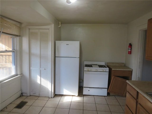 kitchen featuring light tile patterned floors and white appliances