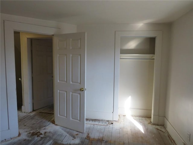 unfurnished bedroom featuring a closet and light hardwood / wood-style floors