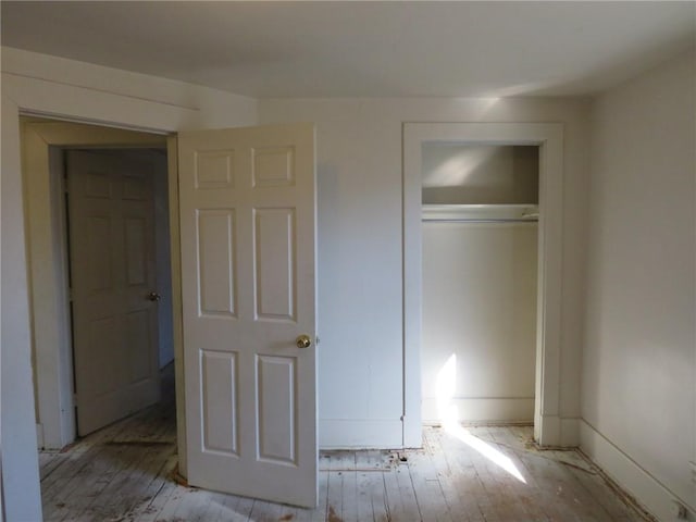 unfurnished bedroom featuring light hardwood / wood-style floors and a closet