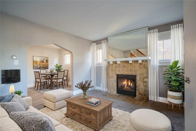 living room featuring a tile fireplace and carpet