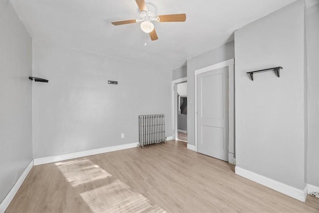 interior space with ceiling fan, light wood-type flooring, and radiator