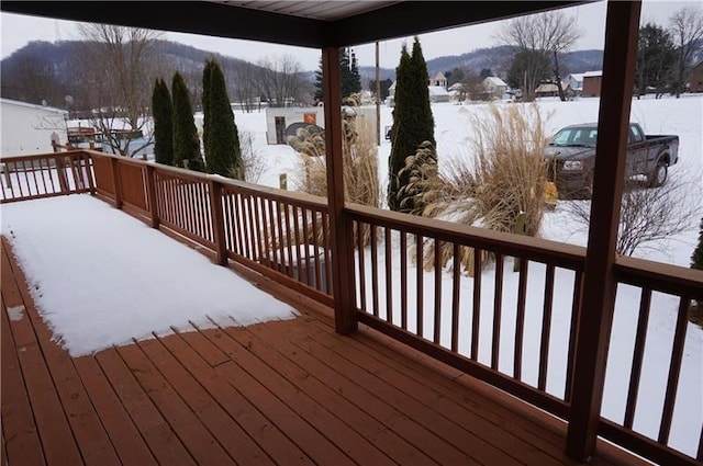 snow covered deck with a mountain view