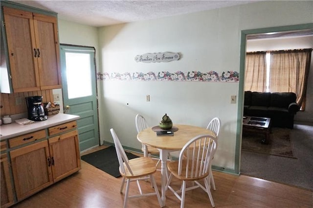 dining room with a textured ceiling and light hardwood / wood-style floors