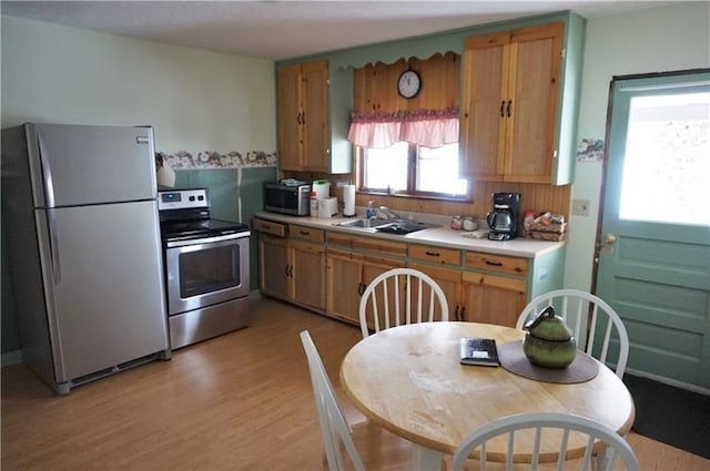 115 Ross St, Confluence Boro, PA 15424 - kitchen with stainless steel appliances, a sink, light countertops, light wood-style flooring, and brown cabinetry