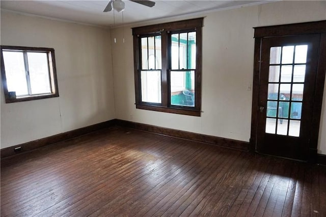 empty room with a wealth of natural light, crown molding, ceiling fan, and dark hardwood / wood-style floors