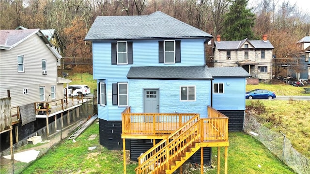 rear view of property with a wooden deck and a yard