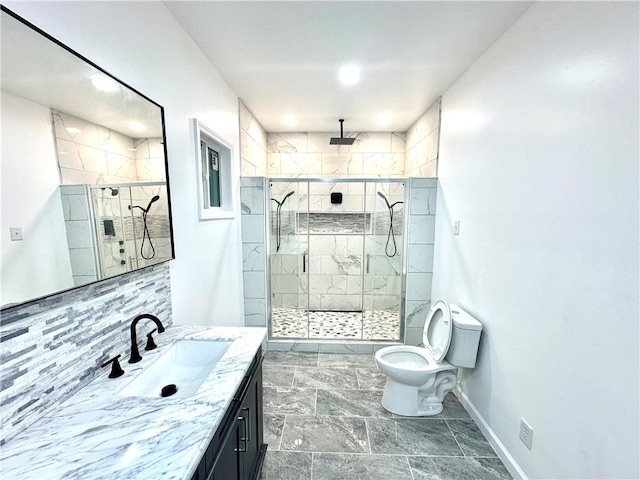 bathroom featuring a shower with door, vanity, and toilet