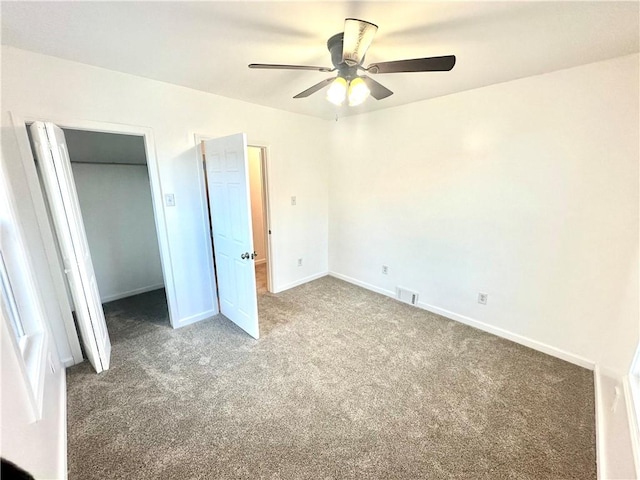 unfurnished bedroom with dark colored carpet and ceiling fan