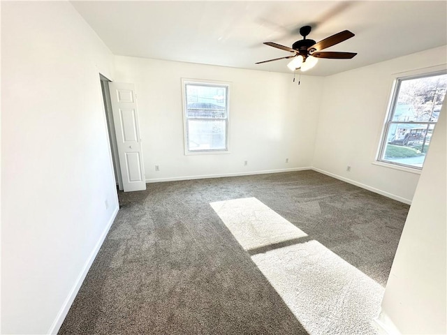 carpeted spare room featuring ceiling fan