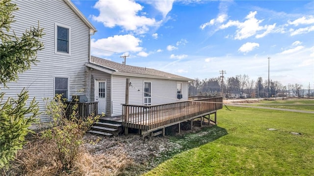 back of house featuring a lawn and a wooden deck