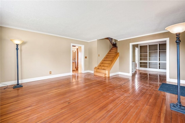 unfurnished living room featuring hardwood / wood-style floors, a textured ceiling, and crown molding