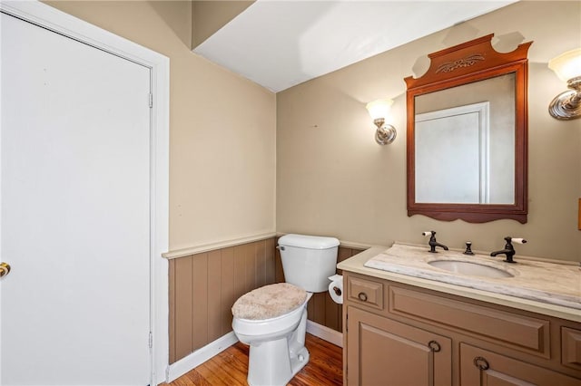 bathroom with toilet, vanity, and hardwood / wood-style flooring