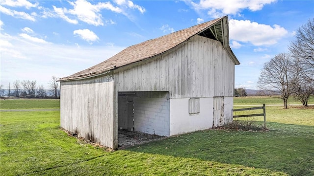 view of outdoor structure featuring a lawn and a rural view