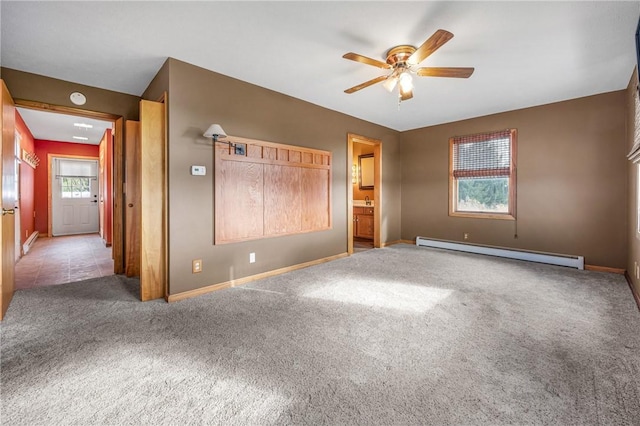 unfurnished bedroom featuring carpet flooring, ensuite bath, ceiling fan, and a baseboard heating unit