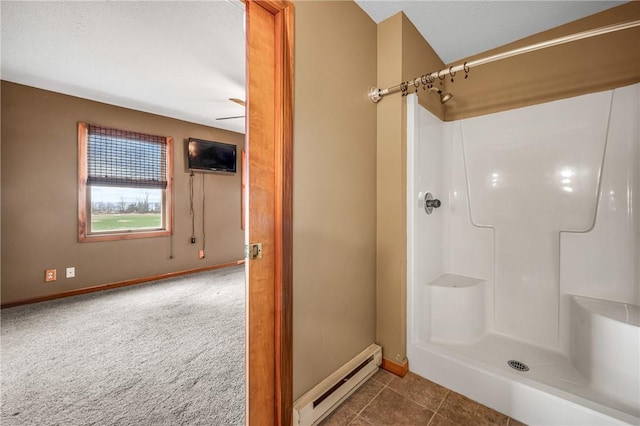 bathroom with tile patterned floors, ceiling fan, a shower, and a baseboard heating unit