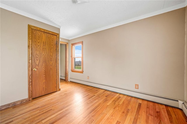 unfurnished bedroom with a textured ceiling, ornamental molding, light hardwood / wood-style flooring, and a baseboard heating unit