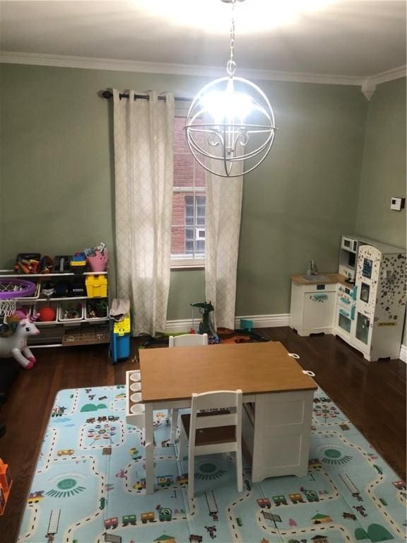 recreation room with dark hardwood / wood-style floors, an inviting chandelier, and crown molding