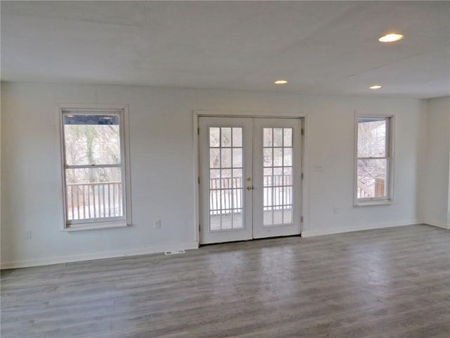 empty room with french doors, recessed lighting, wood finished floors, and a healthy amount of sunlight