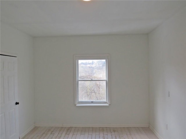 unfurnished room with light wood-style floors and baseboards