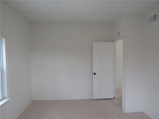 unfurnished room featuring light wood-style floors, baseboards, and visible vents