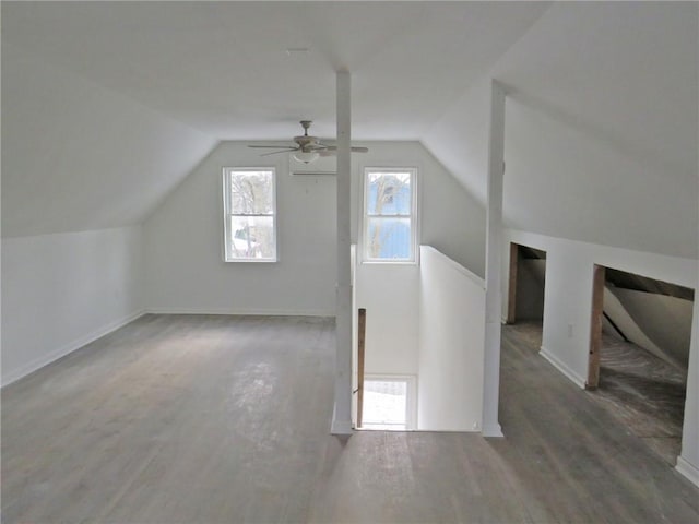 additional living space featuring a ceiling fan, vaulted ceiling, baseboards, and wood finished floors