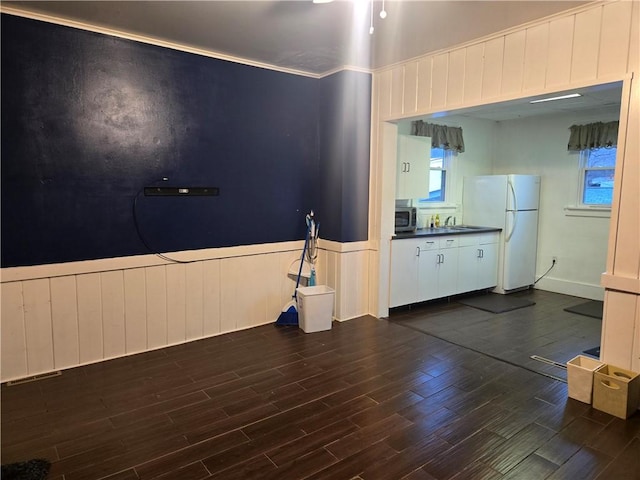 kitchen featuring sink, dark hardwood / wood-style floors, crown molding, white fridge, and white cabinets