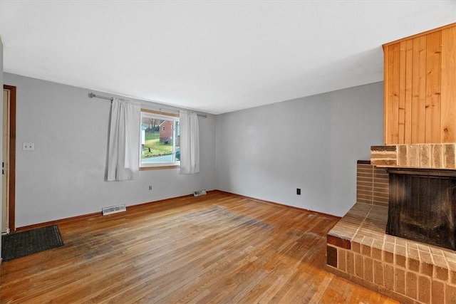 unfurnished living room with hardwood / wood-style flooring and a fireplace