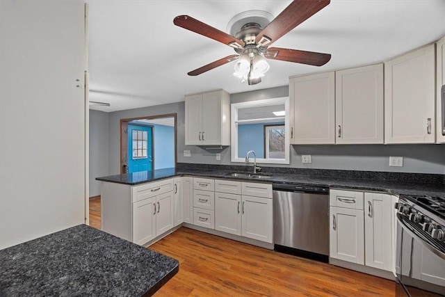 kitchen featuring stainless steel appliances, ceiling fan, sink, light hardwood / wood-style flooring, and white cabinetry