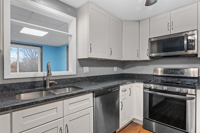 kitchen with ceiling fan, sink, light hardwood / wood-style floors, white cabinets, and appliances with stainless steel finishes