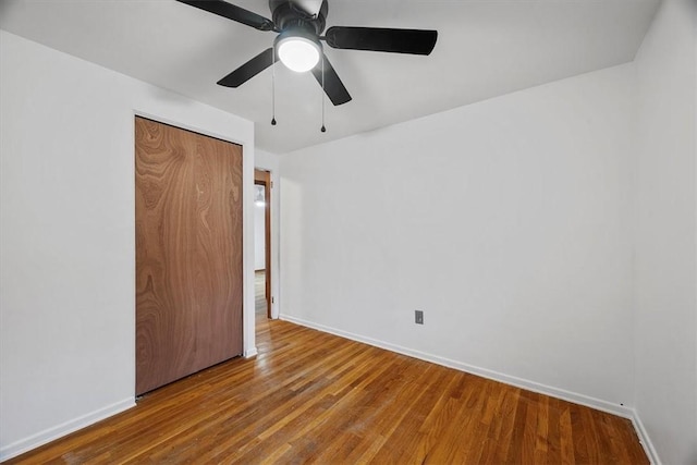 unfurnished bedroom with hardwood / wood-style floors, ceiling fan, and a closet