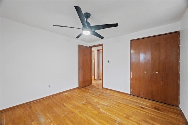 unfurnished bedroom featuring ceiling fan, a closet, and light wood-type flooring