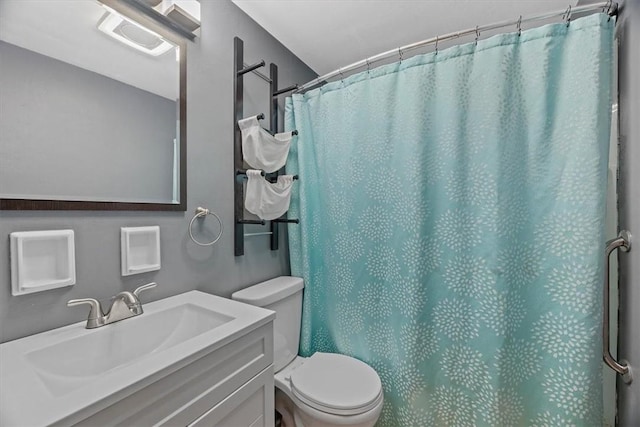 bathroom with curtained shower, vanity, and toilet