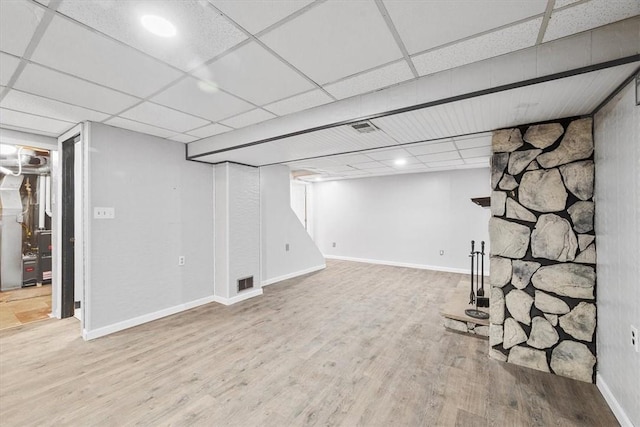 basement with a paneled ceiling and hardwood / wood-style flooring