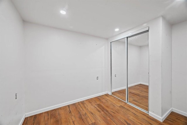 unfurnished bedroom featuring hardwood / wood-style flooring and a closet