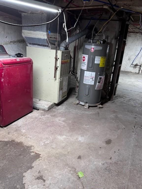 utility room featuring heating unit, water heater, and washer / dryer