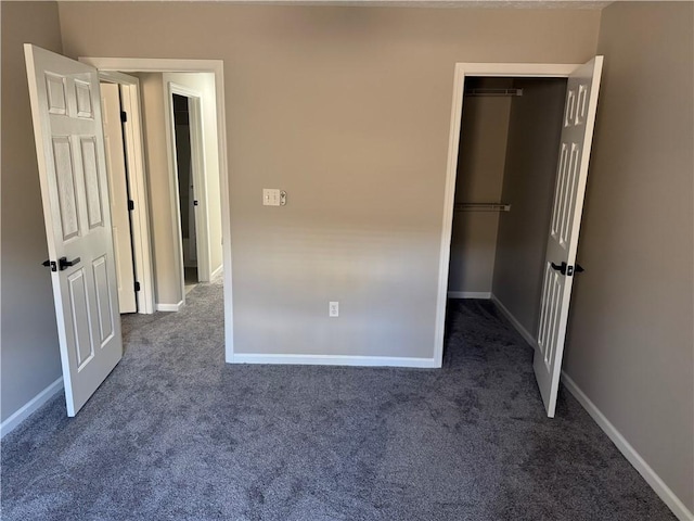 unfurnished bedroom featuring a closet and dark carpet