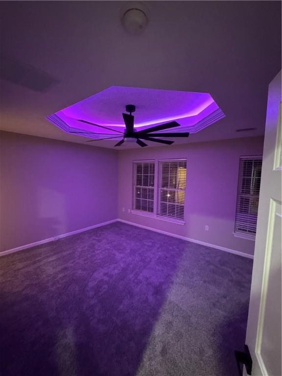 interior space with ceiling fan and a raised ceiling