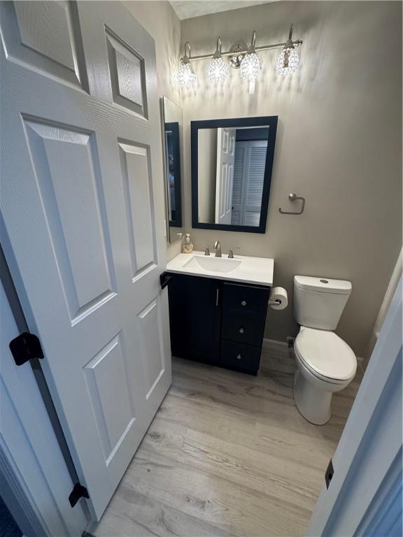 bathroom with hardwood / wood-style flooring, vanity, and toilet