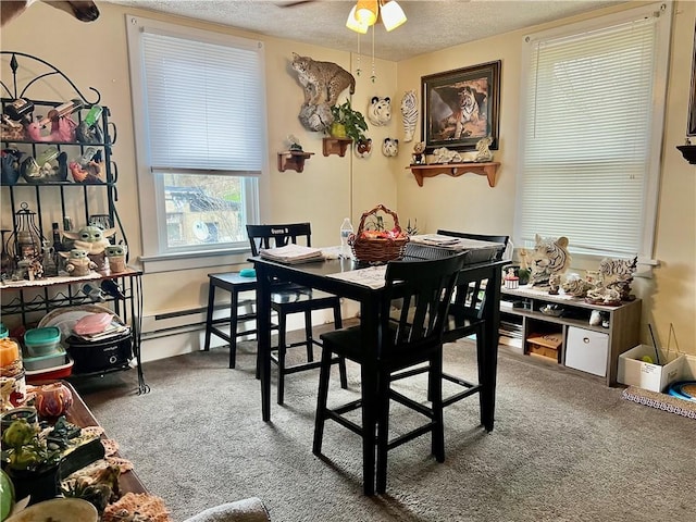 carpeted dining space featuring ceiling fan, baseboard heating, and a textured ceiling