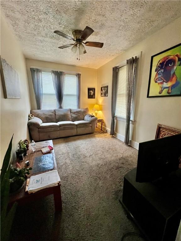 living room with carpet, a textured ceiling, and ceiling fan