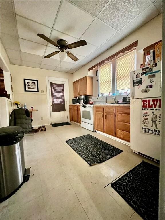 kitchen with white appliances, ceiling fan, a paneled ceiling, and sink