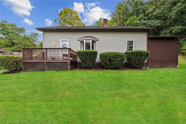 rear view of property with a lawn and a wooden deck