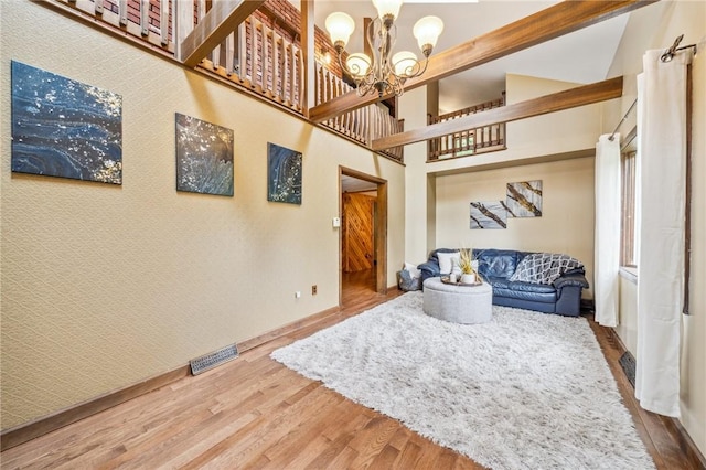 living room with wood-type flooring, lofted ceiling, and a notable chandelier