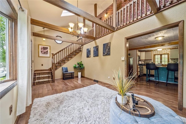 living room with dark hardwood / wood-style floors and an inviting chandelier